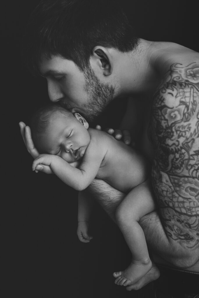 Neugeborenes Baby schläft in Papas Arm – Peach & Berries Fotografie Graz