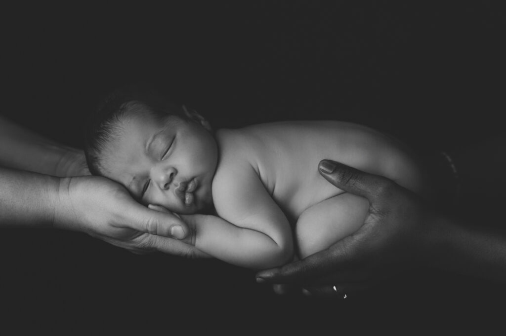 Neugeborenes Baby in Händen der Eltern – Peach & Berries Fotografie Graz