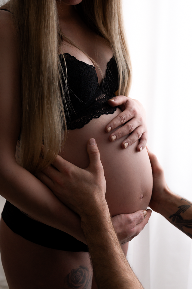 Schwangere Frau hält liebevoll ihren Babybauch – Babybauchshooting Graz